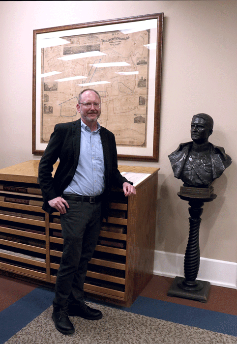 Eric Dawson stands by a bust in the East Tennessee History Museum where he works as an archivist