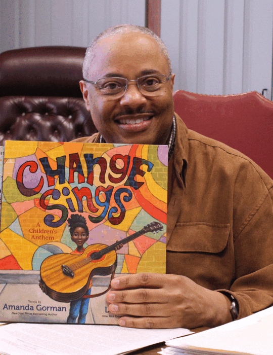 Alvin Blount holding a children's book, "Change Sings"